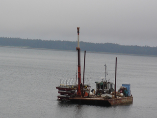 Barge moving floating walkway to site.